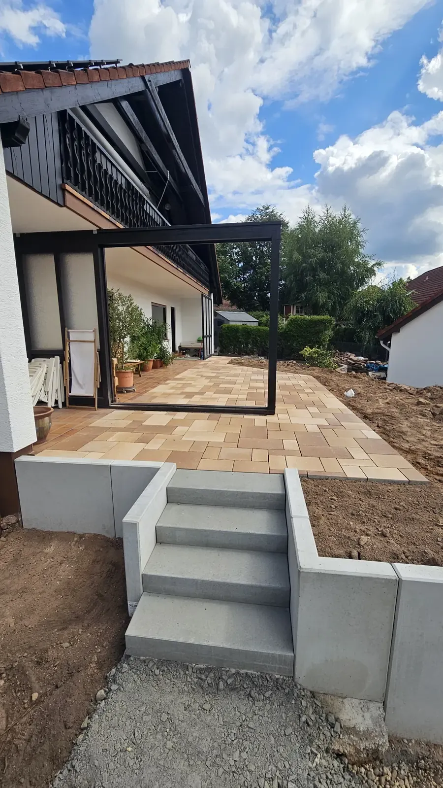 Neue Terrasse mit Pergola und Stufen in den Garten
