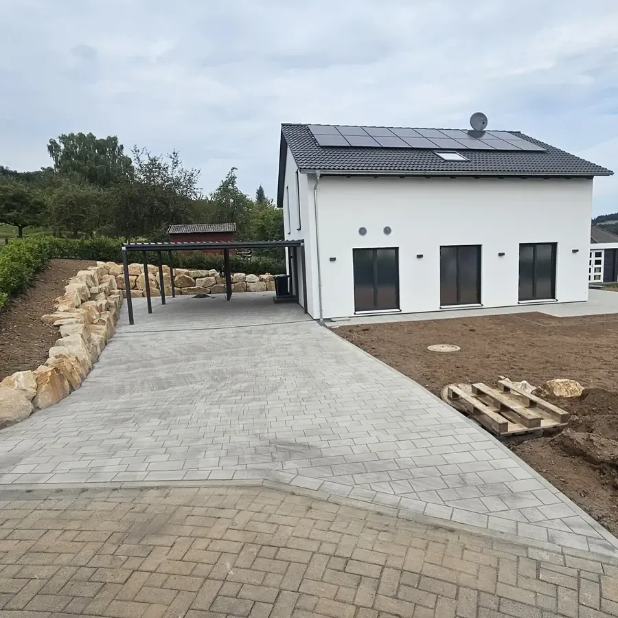 Neue Einfahrt am Neubau mit Natursteinen am Rand