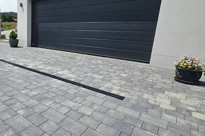 Gepflasterte Einfahrt mit Entwässerungsrinne vor der Doppelgarage