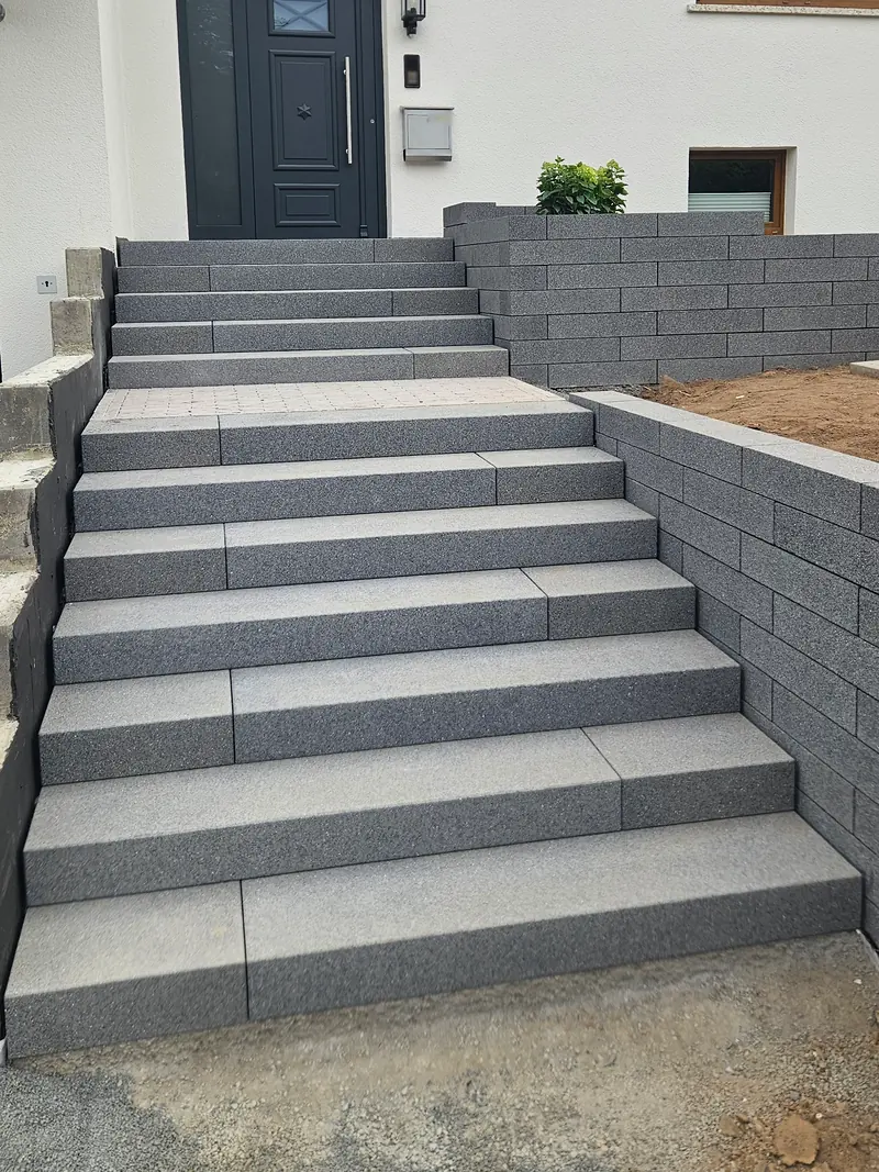 Treppe aus Blockstufen von vorn, oben die Haustür