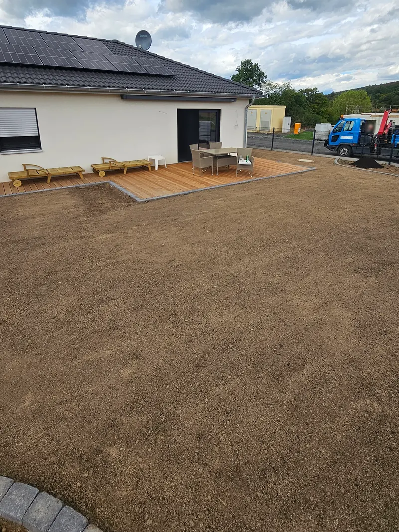 Bungalow mit Holzterrasse und vorbereiteter Rasenfläche