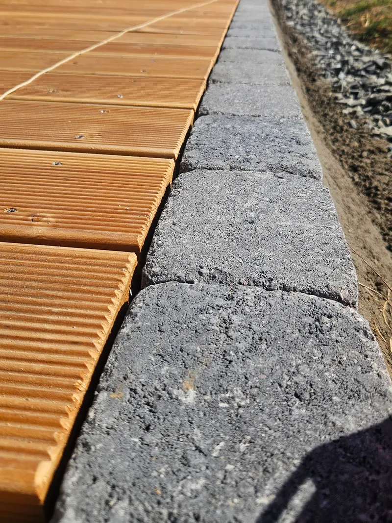 Holzdielen und Einfassung aus Pflastersteinen aus der Nähe