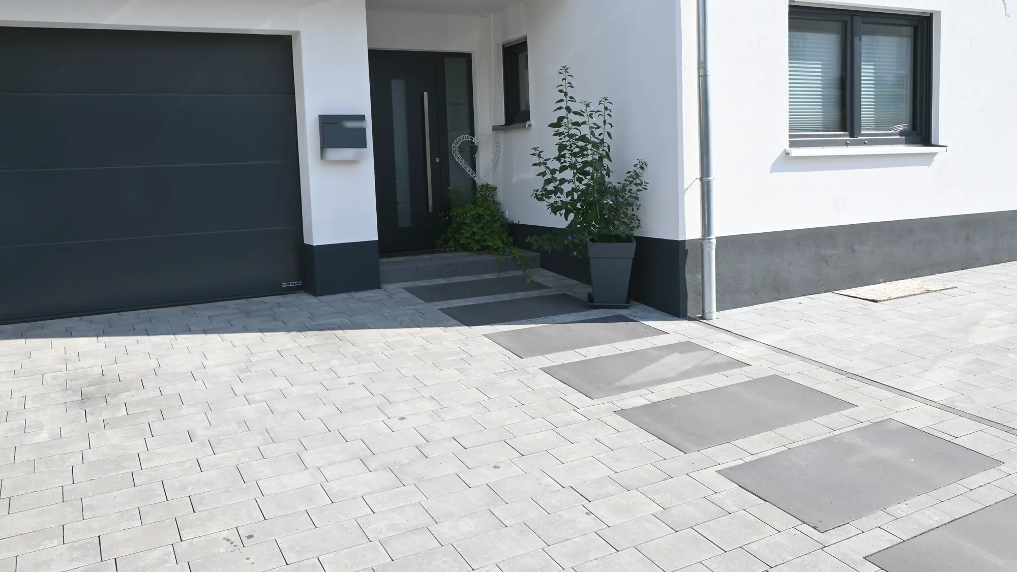 Gepflasterte Einfahrt mit großen Trittplatten zur Haustür